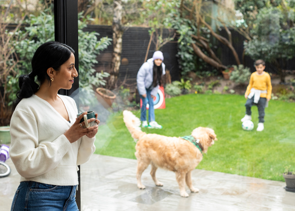 Women looking out into their garden at her dog and kids playing