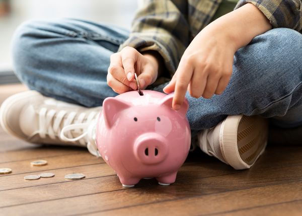 Kid putting money into a piggy bank